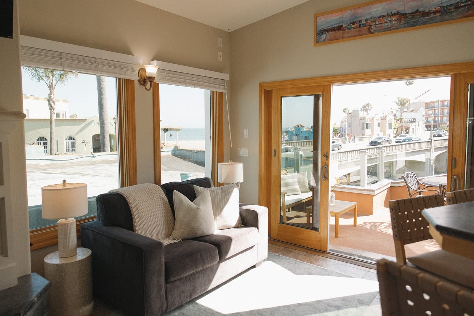 Upstairs living room with a charcoal sofa and windows toward the village